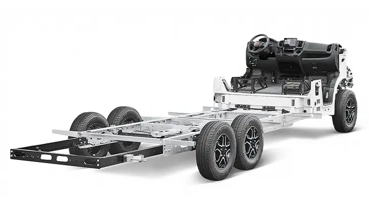 A 3D-rendered image of a Fiat Ducato motorhome chassis with six wheels, an exposed metal frame and visible dashboard and steering wheel at the front. The body and exterior panels are missing.