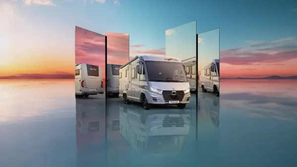 Ein Wohnmobil wird bei Sonnenuntergang auf einer spiegelnden Fläche geparkt, umgeben von großen Spiegeln, die verschiedene Blickwinkel und Reflexionen des Fahrzeugs vor einem farbenfrohen Himmel zeigen.