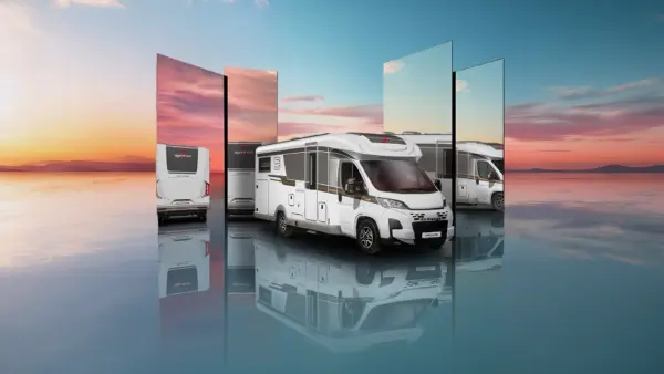 Ein weißes Wohnmobil wird bei Sonnenuntergang auf einer glänzenden, wasserähnlichen Fläche geparkt, wobei große Spiegel verschiedene Blickwinkel auf das Fahrzeug und den farbenfrohen Himmel reflektieren.