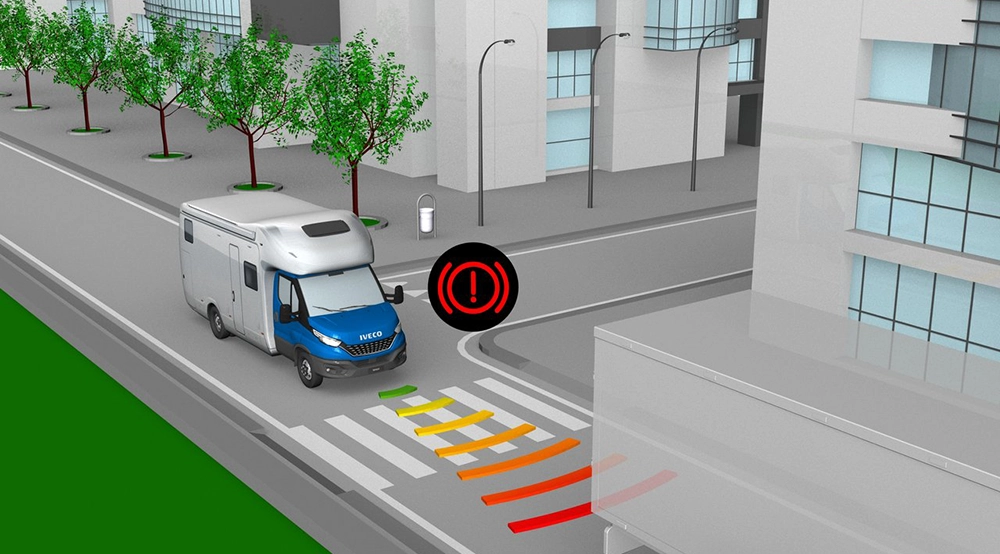 Ein blau-weißes Iveco Daily Wohnmobile nähert sich einem Zebrastreifen in einer Stadtstraße. Bunte Linien und ein Bremswarnsymbol verdeutlichen, dass das automatische Notbremssystem des Fahrzeugs ein Hindernis vor ihm erkennt.